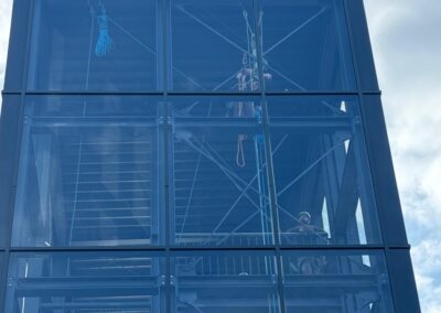 Blick auf die Glasfassade während der Reinigung durch Industriekletterer