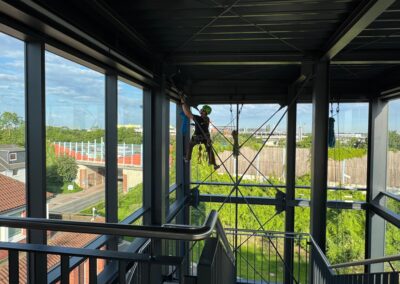 Glasreinigung an einem Treppenhaus mit vollständig verglaster Fassade